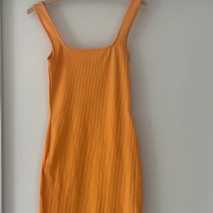 Orange lång klänning  - Jättefin orange lång klänning. Slutar under knäna på mig jag är 171cm. Den är i storlek xs men passar en S/m. Materialet är väldigt stretchigt samtidigt som den sitter åt på ett snyggt sätt🧡