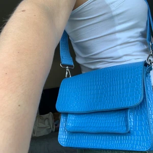 Hvisk väska - Drömblå väska från Hvisk. Säljer även ett rosa kedjeväskband till (annan annons). Bra skick. 