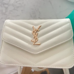 YSL väska  - • Ny YSL väska •Köpt utomlands  • rymmer väl  • Vit med guld detalj  •snygg och enkel• oäkta