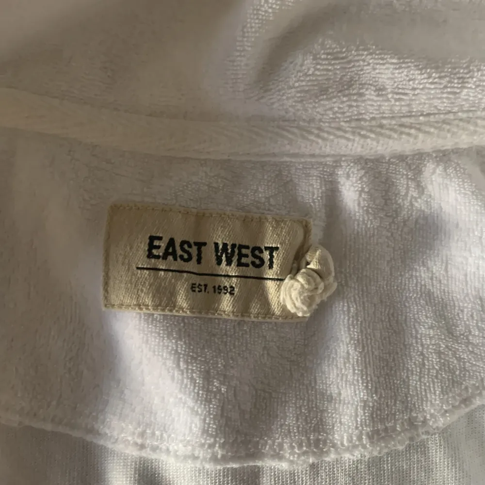 En fin vit piké från East West i skön frottematerial med dragkedja. Säljer pga att den inte kommer till användning . Släng iväg ett meddelande så löser vi pris. T-shirts.