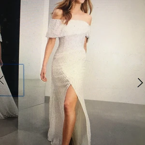 Klänning med paljetter  - Säljer nu en magisk vit klänning med paljetter som har ett litet släp. Klänningen är använd en kväll som ombyte vid ett bröllop och därefter kemad så ser ut som ny!  Klänningen passar både en 38a och en storlek 40.   Nypris: 2679kr 