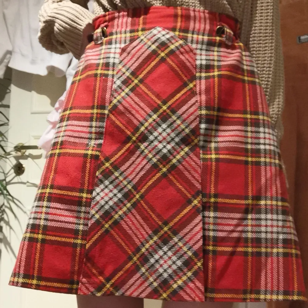 Snygg kjol med schackmönster i ull, polyester och akryl. Unikt skuren design på kjolen. Bekväm och går att justera med två stycken tillkommande 