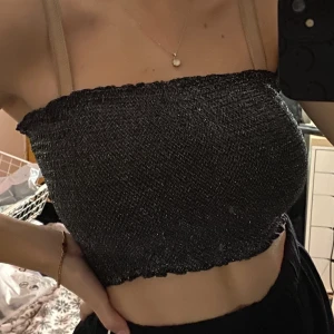 Glittrig tubtopp  - En söt glittrig tubtopp från bikbok. Aldrig använt, prislappen är kvar. Sitter skönt, fint material. Glittret sitter där det sitter, den fäller alltså inte!!  Jag har storlek 65h i byst om det hjälper någon :)