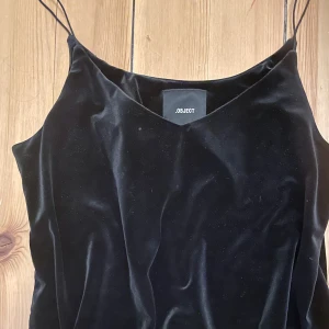 Sammetslinne i hög kvalitet - Det är så här riktigt fin sammet känns! Detta linne är något A-skuret och alltså inte alls tajt. Istället fallet den tunga och täta sammeten på ett fantastiskt vackert sätt.  Kolsvart. Använder en gång. 