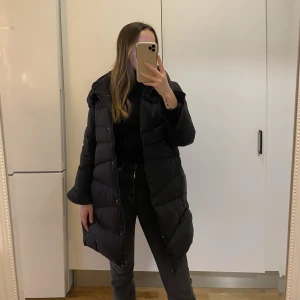 Svart vinterjacka  - Svart, fluffig och varm vinterjacka.  Passar en S/M. Två fickor på sidorna och en innerficka. Spårbar frakt: 66kr.