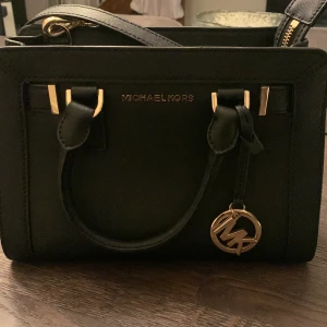 Michael Kors Dillon small - Svart äkta Michael Kors Dillon small. I fint skick. Sparsamt använd. Innertyg rent och fint utan slitage. Utsida utan någon som helst anmärkning. Tags finns kvar.