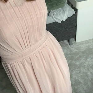 Klänning, rosa - Använd en gång vid skolavslutning, har en bra passform och spets på sidan baksidan. Går precis ovanför fötterna, jag är 169 cm lång. Dragkedjan kan va lite trög. Inte genomskinlig och har gummi vid kanten av bysten.