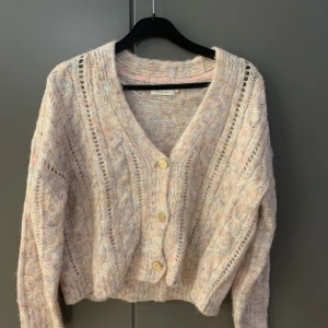 Stickad kofta  - Rosa & blå stickad kofta från Only. Korten är väldigt varm och mysig och medföljer även en extra guldknapp. 