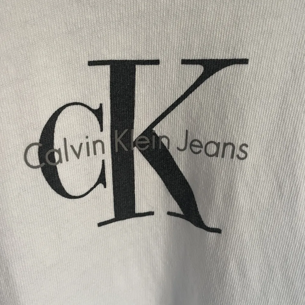 Ikonisk vit t-shirt 100% bomull med vintagekänsla från CK butik i Amsterdam. Löst uppvikta ärmar. Sömmen har släppt på insidan bak, enkelt att fixa, se bild.. T-shirts.