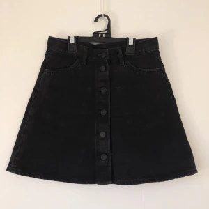 Jeanskjol Monki - A-linjeformad minikjol från Monki, i svart denim med lite tvättad finish samt fickor fram och bak. Aldrig använd, nyskick. Sista bilden är lånad från hemsida och visar passformen.