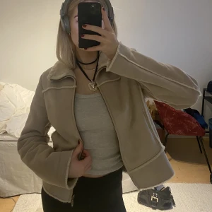 Beige jacka - En beige mocka/pälsjacka (fejk). Storlek L men jag skulle säga att den är betydligt mindre än så då jag vanligtvis har S! 