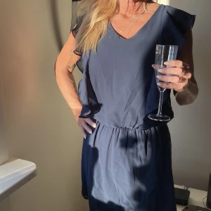 Klänning  - Mörkblå supersöt klänning med gummiband i midjan och volanger på ärmarna 