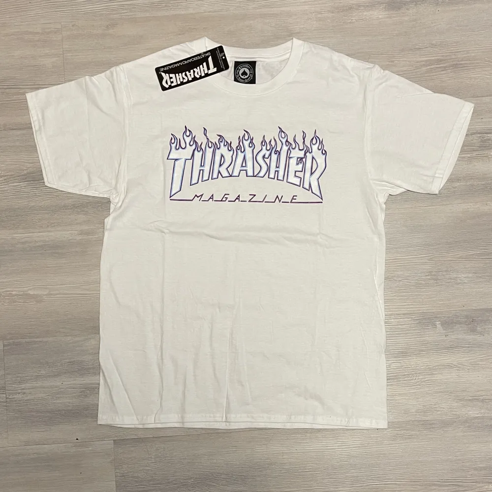 Helt ny t-shirt från trasher med lila och vit text, helt ny och oanvänd med prislappen kvar. T-shirts.