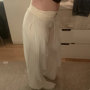 Vita flowiga byxor - Flowiga vita byxor med en textur av leggings och har tyg bitar på framsidan och baksidan, dem är väldigt sköna men har aldrig använt dem för något 