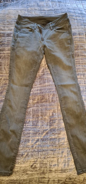 G-star. Dam. 26-30. - Använda 1 gång. G-star Jeans köpta på G-star. Gråa. Pilot-gylf. Extra knappen (som är onödig)  på innerstidan är borta. Ingenting som varken syns eller behövs. Men därav säljer jag dom billigare. Jeansen kostar 1799 kr i butik. 