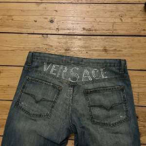Säljer dessa asfeta lågmidjade jeans från Versace Jeans🤩 Inköpta på Plick och bilderna är lånade från förra ägaren, men det är bara att skriva för fler bilder!! Dom passar mig som är ca 165 cm lång. Midjemåttet är ca 85, men det går att dra åt i midjan🤍