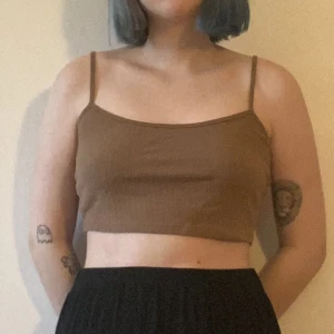 Brun croptop - Stretchigt material, passar S-L. Justerbara band. Använd två gånger.