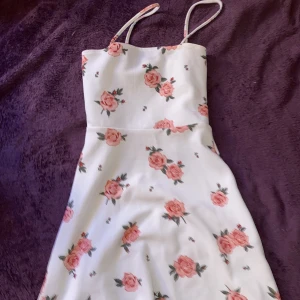 Sommarklänning - Vit kort klänning med blommor. Relativt tjockt material. 