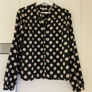 ’Satin’ blus  - Blus i fint skick. Använt sparsamt. Lite glansig, små knappar nerifrån och upp. Lätt att klä upp eller ner. Från NAKD