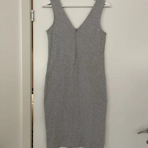 Klänning - En grå ribbad klänning i storlek S(36/38). Supermjuk med en underklänning i vilket gör att det ger lite mer stadga i tyget och snyggare form på kroppen. Likadan dragkedja fram som bak. Aldrig använd med lappen kvar. 🤍