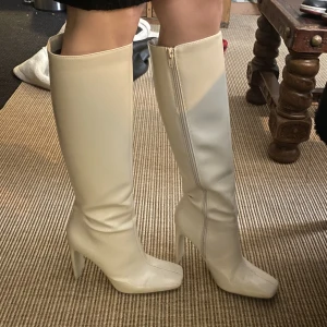 Vita högklackade boots - Fina vita högklackade boots från ZARA, använda ett fåtal gånger. Nypris 700