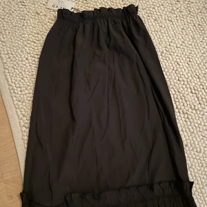 Kjol - Helt ny med lappar kvar, har volanger både uppe och nere. Storlek 34