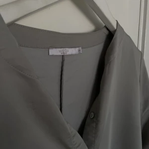 Grå blus WERA  - Jättefin ”glansig” blus. Ord pris 500kr, från WERA, jättebra skick och använd ett fåtal gånger.