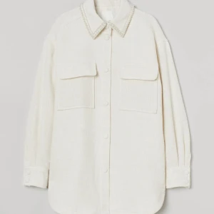 Skjortjacka H&M - Vit skjortjacka med pärlor på kragen från H&M. Använd sparsamt så därmed i fint begagnat skick.