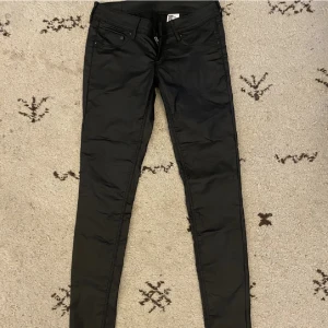 Low waist - Låg midjade byxor i fejk läder, matt. Storlek W26L30