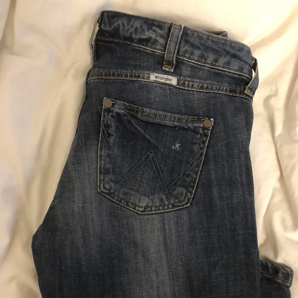 Low waist Wrangler jeans i modellen ”Eve”, W29 L32. Jättefin marin blå tvätt men tyvärr alldeles försmå för mig. Utsvängda i kanten🤍Mått: 40 cm midja/höft, 100 cm total längd, 79 cm ben, benvidd nedtill 22 cm. Jeans & Byxor.