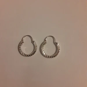 Örhängen i silver - Örhängen i äkta silver. Supervackra små ringar med mönster. Helt oanvända.  Ask: 10 kr (valfritt) Frakt: 15 kr