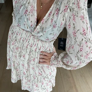 Klänning Nakd - Säljer min jättefina blommiga klänning i storlek 34 från Nakd! Den är helt oandvänd och prislappen sitter kvar!❤️