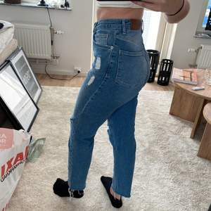 Blåa jeans från NAKD med små hål på knäna, storlek 34 men tycker mer att det är som 36, sitter som en smäck. Säljs för 180kr, köpare står för frakt. (Jag är 36 i storlek och 170cm lång)