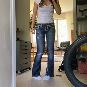 bootcut true religion jeans  - säljer dessa as snygga true religion bootcut jeansen med ett hål i knät ( ska vara så ) i st 25, as bra skick. midjemåttet är ca 74 cm och innerbenslängden är ca 77 cm‼️kontakta mig INNAN du vill köpa‼️ 