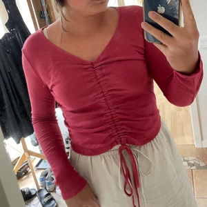 Justerbar tröja - Tröjlängden kan justeras genom att knyta smörerna på framsidan. Baksidan är alltid lika lång, ungefär som bild 1. 