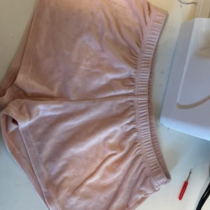 Ljus rosa pyamasbyxor - Shortsen har används mycket men det har inte gett några skador på shortsen(förutom att man inte kan se storleken.Shortsen är pyamasshorts.Det finns stjärnor på shortsen. Man kan inte se stleken på shortsen eftersom  den lappen har försvunnit.Tror deär sx