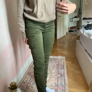 Gröna cargobyxor - Säljer dessa tighta cargobyxor från zara. Tyvärr finns det två hål (se bild) vid sidorna men utöver det är de i mycket bra skick. Modellen är runt 166 cm lång.