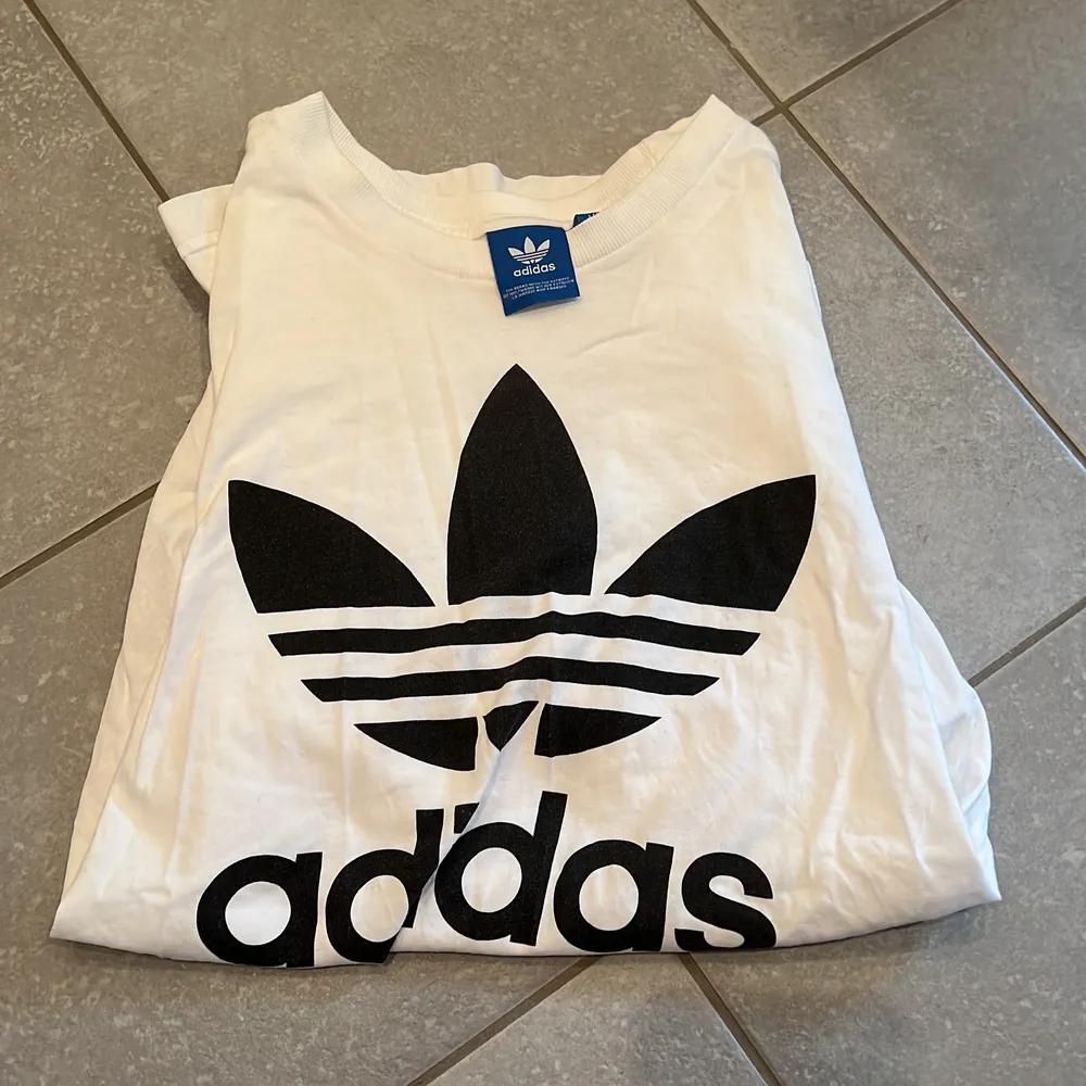 En vit t-shirt från adidas, större i storleken. T-paidat.