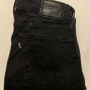 Svarta Levis lågmidjade jeans midja 26 längd 30 - Säljer dessa lågmidjade jeans från Levis. Midjan är 26, längden är 30 Köptes för 1000:- för något år sedan, säljer för 300:- Passar mig perfekt som är 1.67