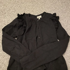 Kofta - Svart liten kofta med spets.