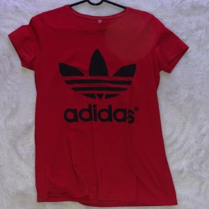Röd Adidas T-shirt Storlek S - En röd adidas t-shirt. Helt oanvänd. Inte äkta men man märker ej det. Storlek S