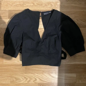 Snygg svart topp öppen rygg - Jätte snygg svart topp med v ringning där fram samt öppen rygg. Urrrrr snygg och har väldigt snygga ärmar! Lyxigt material och väldigt bekvämt. Köpt på only 