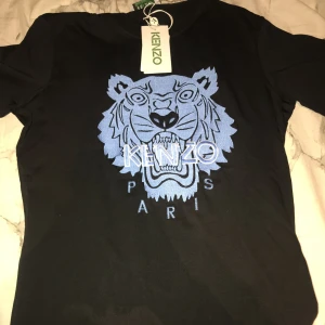 Kenzo T-shirt - Säljer en jättefin kenzo T-shirt. Nyskick aldrig använd prislappen finns kvar. Skriv för fler bilder. Har 2 likadana i lager