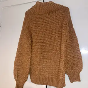 Oversized knitted sweater in a nice pumpkin spice color. The cowl-neck is very thick and comfortable and the sleeves are ballooned.