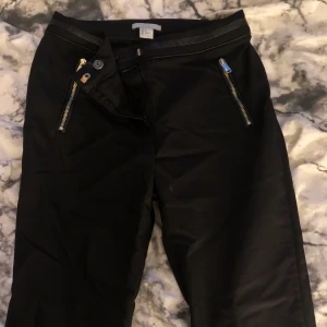 kostymbyxor - Kostymbyxa som är lägre i midjan, slutar precis vid naveln, riktigt snygg passform med fina detaljer på. Ej fickor, jag är runt 170 och de är lite för korta för min smak.