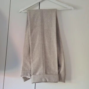 Flanellbyxor - Suitsupply (Stl 94/Medium lång)  - Specialbeställde dessa byxor från Suitsupply för två år sedan. Har använts enbart ett par enstaka tillfällen men får tyvärr inse att jag inte längre kommer i dem efter pandemin. Väldigt fina med hög midja och slag.   Stl är 94. Se guide hos Suitsupply. 