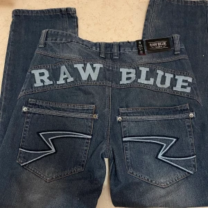 Baggy jeans - baggy jeans ”RAW BLUE” står på baksidan. Passar bra på mig som 34 men skulle även passa större storlekar. Funkar både uppvikta och nervikta i midjan som på bilderna. Waist 32 och Lenght 32. (Psst, skorna finns också att köpa i profilen!😋) 400KR SNABB KÖP!