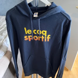 Le coq sportif  - Le coq sportif huvtröja utan dragkedja. Riktigt skön och i mycket bra skick. Märket är fransk och är mörkblå och i storlek M.