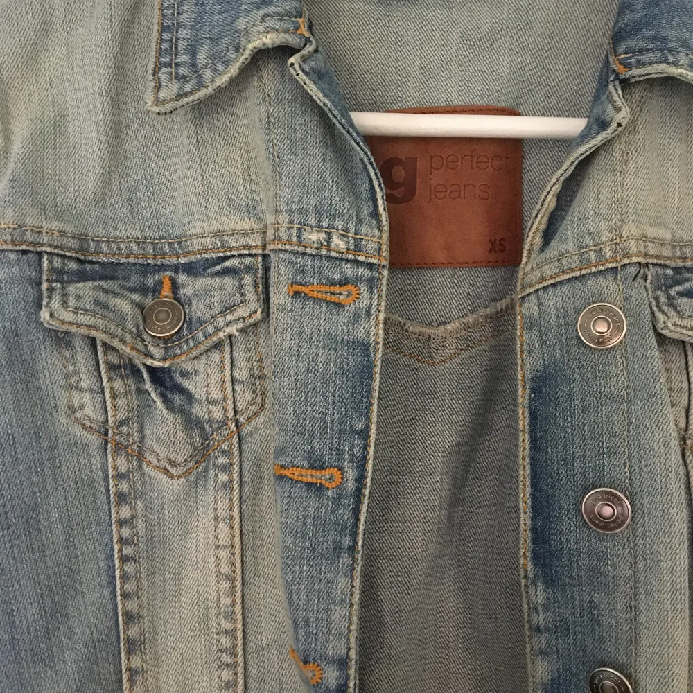 Blå jeansjacka med slitningar från Gina Tricot. Två bröstfickor. Storlek XS. Jackor.