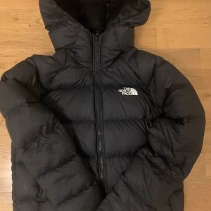 North face jacka  - Jättesnygga trendig north face jackan med luva. Den är i storlek M men sitter mer som S. Den köptes på north face hemsida för 3200kr. Det blev ett hål som vi har sytt ihop som ni ser på den andra bilden. KÖP DIREKT FÖR 1500 + FRAKT